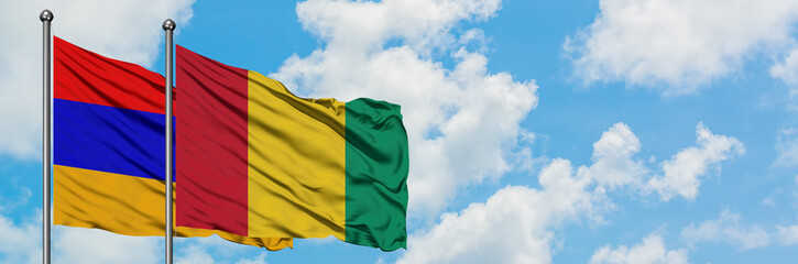 Armenia and Guinea flag waving in the wind against white cloudy blue sky together. Diplomacy concept, international relations.