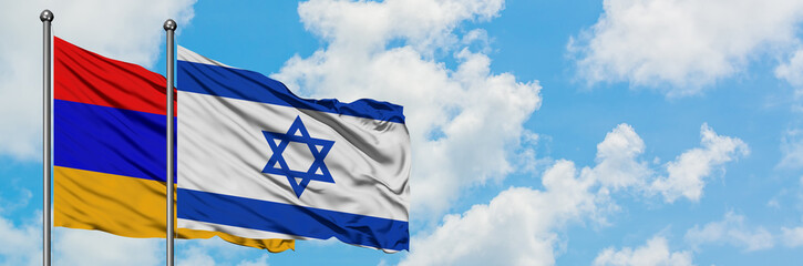 Armenia and Israel flag waving in the wind against white cloudy blue sky together. Diplomacy concept, international relations.