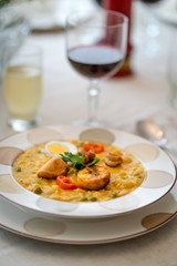 Typical dish of Ecuadorian food, soup based on cod fish, with milk and many grains, served with fried plantain, fried wheat dough and hard-boiled egg