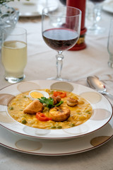 Typical dish of Ecuadorian food, soup based on cod fish, with milk and many grains, served with fried plantain, fried wheat dough and hard-boiled egg