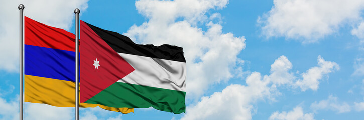 Armenia and Jordan flag waving in the wind against white cloudy blue sky together. Diplomacy concept, international relations.