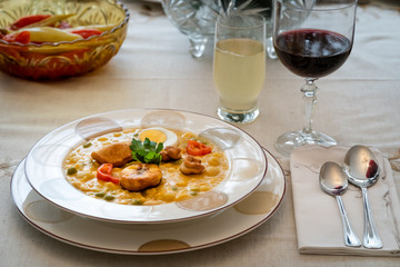Typical dish of Ecuadorian food, soup based on cod fish, with milk and many grains, served with fried plantain, fried wheat dough and hard-boiled egg