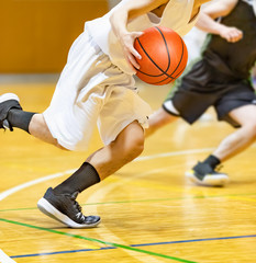 バスケットボールの試合をする学生