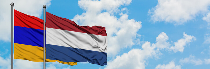 Armenia and Netherlands flag waving in the wind against white cloudy blue sky together. Diplomacy concept, international relations.