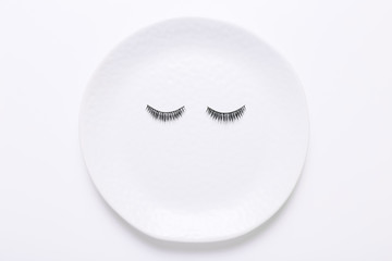 False eyelashes in white round on white background
