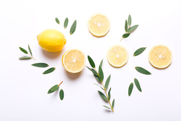 Fresh sliced lemon with green leaves on white background, top view