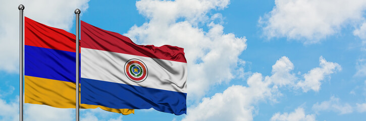 Armenia and Paraguay flag waving in the wind against white cloudy blue sky together. Diplomacy concept, international relations.