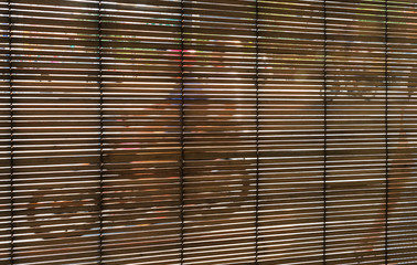 Motorcycle riding and street activities seen through the bamboo curtain, Penang, Malaysia.
