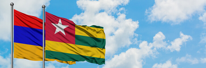 Armenia and Togo flag waving in the wind against white cloudy blue sky together. Diplomacy concept, international relations.