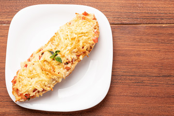 Bruschetta with tomatoes, mozzarella cheese and basil on a wooden background. Traditional italian appetizer or snack, antipasto. Isolated