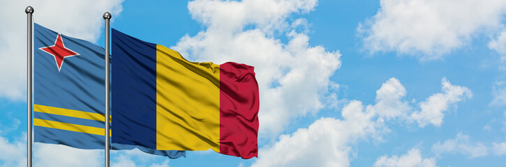 Aruba and Chad flag waving in the wind against white cloudy blue sky together. Diplomacy concept, international relations.