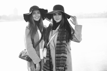 Fashionable girls in a winter city. Stylish ladies in a coats. Woman in a hat