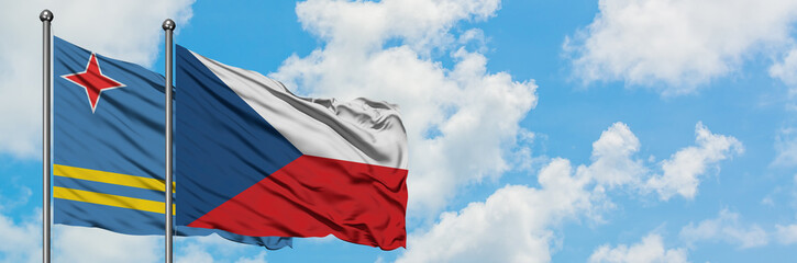 Fototapeta na wymiar Aruba and Czech Republic flag waving in the wind against white cloudy blue sky together. Diplomacy concept, international relations.