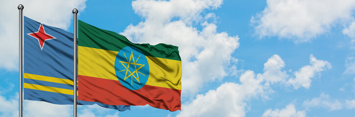 Aruba and Ethiopia flag waving in the wind against white cloudy blue sky together. Diplomacy concept, international relations.