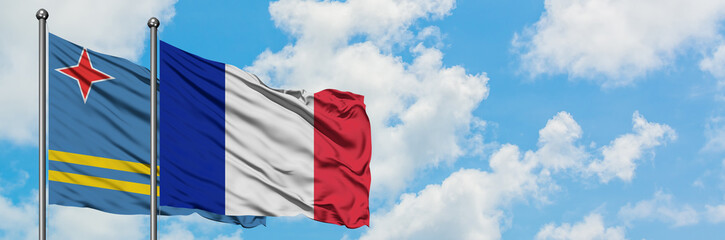 Aruba and France flag waving in the wind against white cloudy blue sky together. Diplomacy concept, international relations.