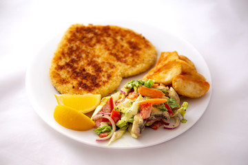 Heart shape Chicken Schnitzel with salad, fried potato wedges
