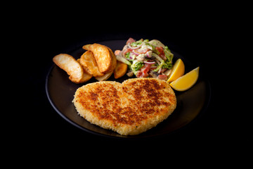 Heart shape Chicken Schnitzel with salad, fried potato wedges