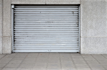 Gray large garage door in a gray wall.