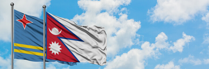 Aruba and Nepal flag waving in the wind against white cloudy blue sky together. Diplomacy concept, international relations.