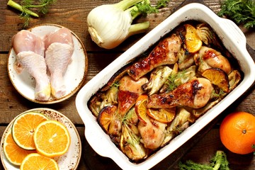 dish with fennel. Baked chicken drumsticks with fennel and oranges. festive dish, popular in the Mediterranean. Keto diet dish. ceramic baking dish. top view. Flatlay