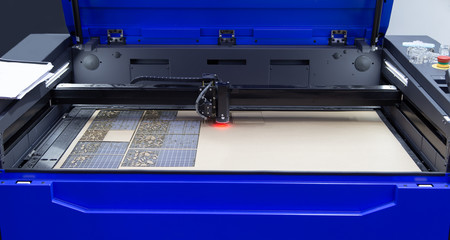 Laser cutting engraving machine cutting leaves pattern on invitation card