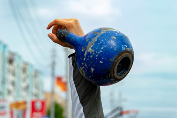 A teenager guy lifted a weight of 16 kilograms. Front view.