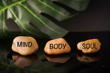 Zen Concept: Mind, Body and Soul wordings on stones against black background 