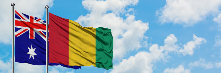 Australia and Guinea flag waving in the wind against white cloudy blue sky together. Diplomacy concept, international relations.