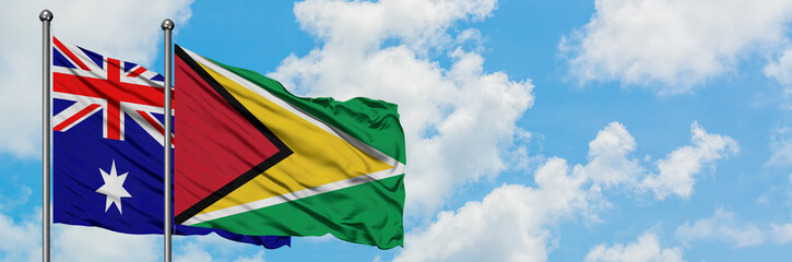 Australia and Guyana flag waving in the wind against white cloudy blue sky together. Diplomacy concept, international relations.