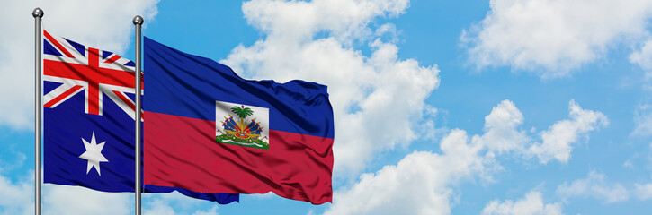 Fototapeta premium Australia and Haiti flag waving in the wind against white cloudy blue sky together. Diplomacy concept, international relations.
