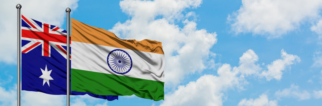Australia and India flag waving in the wind against white cloudy blue sky together. Diplomacy concept, international relations.