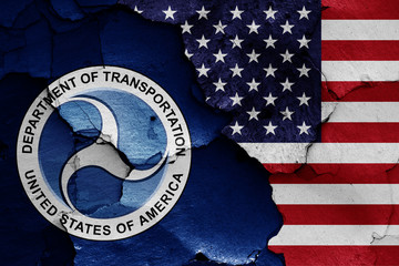 flags of Department of Transportation and USA painted on cracked wall