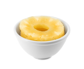 Bowl with slices of delicious sweet canned pineapple on white background