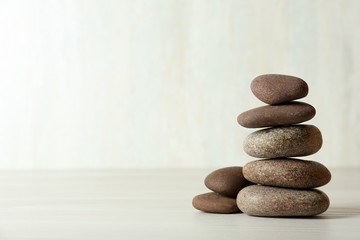 Fototapeta na wymiar Stack of spa stones on table against white background, space for text