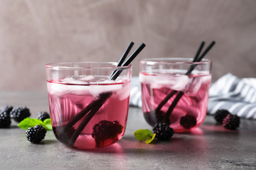 Delicious refreshing blackberry lemonade on grey table
