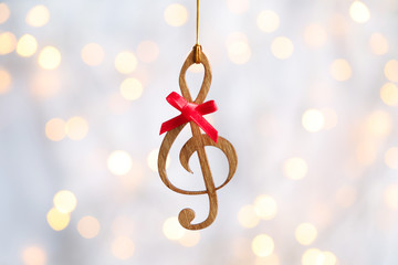 Wooden treble clef against blurred lights. Christmas music