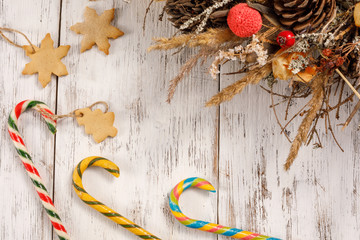 Christmas caramel canes and cookies on an aged white wooden background. Happy new year background, composition of christmas decorations. Holiday concept.