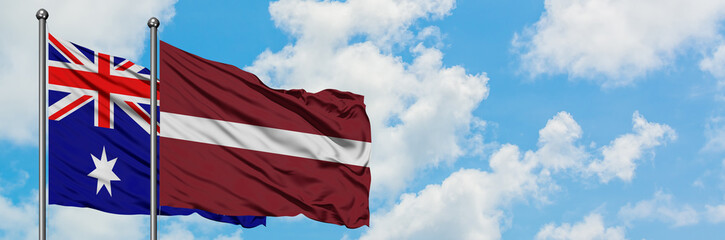 Fototapeta na wymiar Australia and Latvia flag waving in the wind against white cloudy blue sky together. Diplomacy concept, international relations.