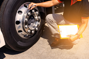 Auto Mechanic is Checking the Truck's Safety Maintenance Checklist. Fixing. Inspection Safety of Semi Truck Wheels Tires. © Siwakorn1933