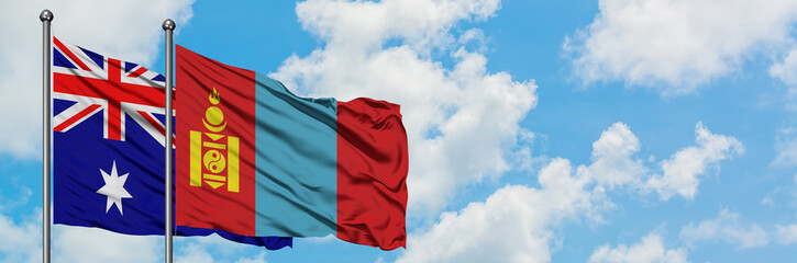 Naklejka premium Australia and Mongolia flag waving in the wind against white cloudy blue sky together. Diplomacy concept, international relations.