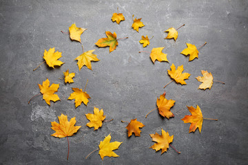 Frame made of autumn leaves on grey stone table, flat lay. Space for text