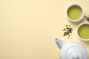 Flat lay composition with green tea on beige background. Space for text