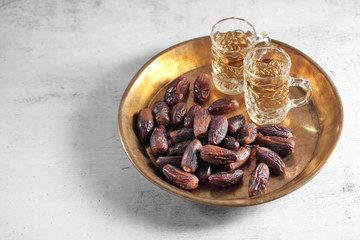 dates fruit and Arab tea on a white concrete background with a blank space for a text, dates fruit on a white background