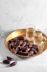 dates fruit and Arab tea on a white concrete background with a blank space for a text, dates fruit on a white background
