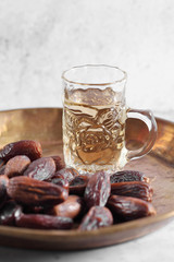Arab tea and dates fruit on a white concrete background with a blank space for a text, tea and dates fruit on a white background