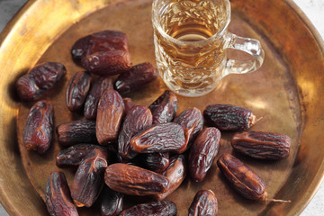 dates fruit and Arab tea on a white concrete background with a blank space for a text, dates fruit on a white background