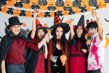 Obraz premium Gang of teen Asian celebrate Halloween for sing a song and drink, dessert in the room.