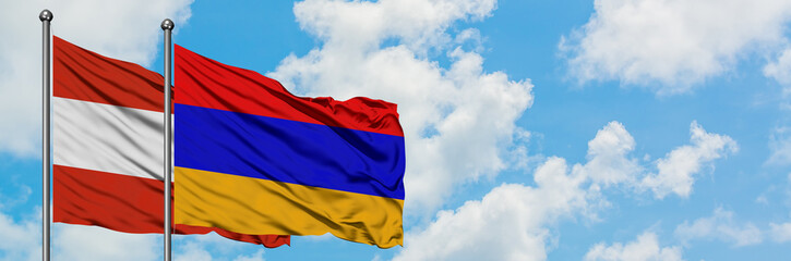 Austria and Armenia flag waving in the wind against white cloudy blue sky together. Diplomacy concept, international relations.