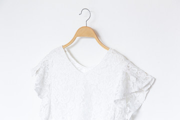 White blouse is clothes hanging on white background.