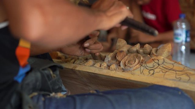 Closeup shot of a master craftsman doing traditional wood carving